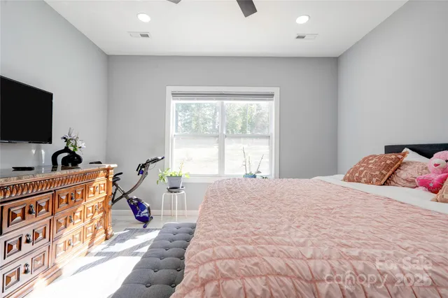 a bed room with a bed a television and a window