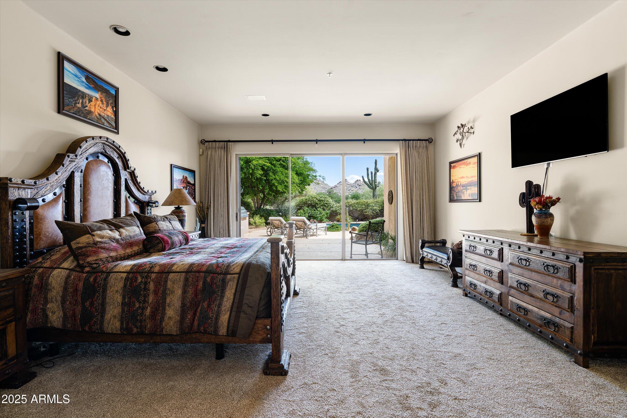 34221 North Boulders Parkway Scottsdale, AZ 85266 - Photo 17 of 31 a bed room with a bed and a flat tv screen on dresser