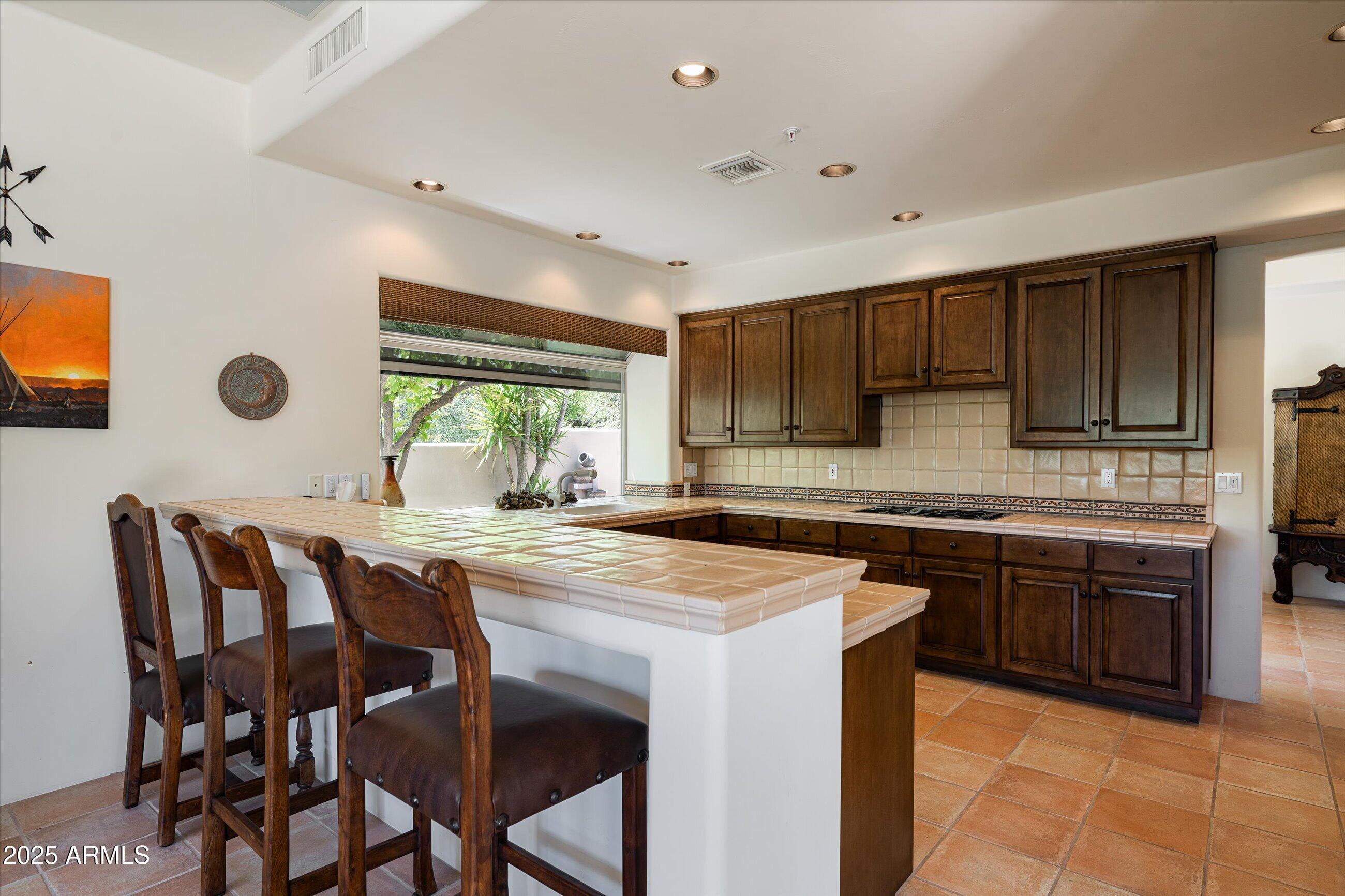 34221 North Boulders Parkway Scottsdale, AZ 85266 - Photo 9 of 31 a kitchen with a table chairs sink and cabinets