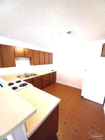 a kitchen with stainless steel appliances a stove a microwave and white cabinets