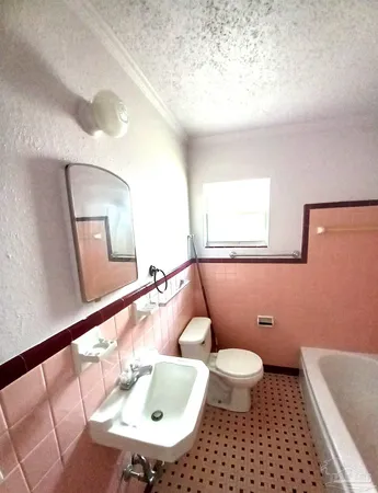 a bathroom with a sink a toilet a mirror and shower