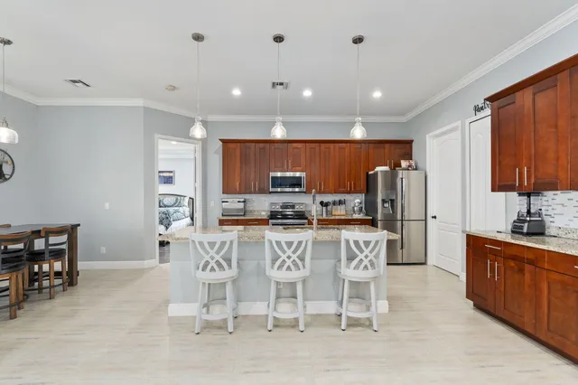a kitchen with stainless steel appliances kitchen island granite countertop a sink and cabinets