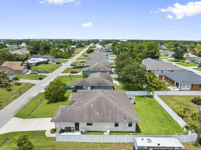an aerial view of residential houses with outdoor space and swimming pool