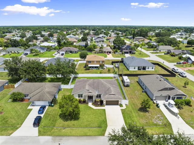 an aerial view of residential houses with outdoor space and parking