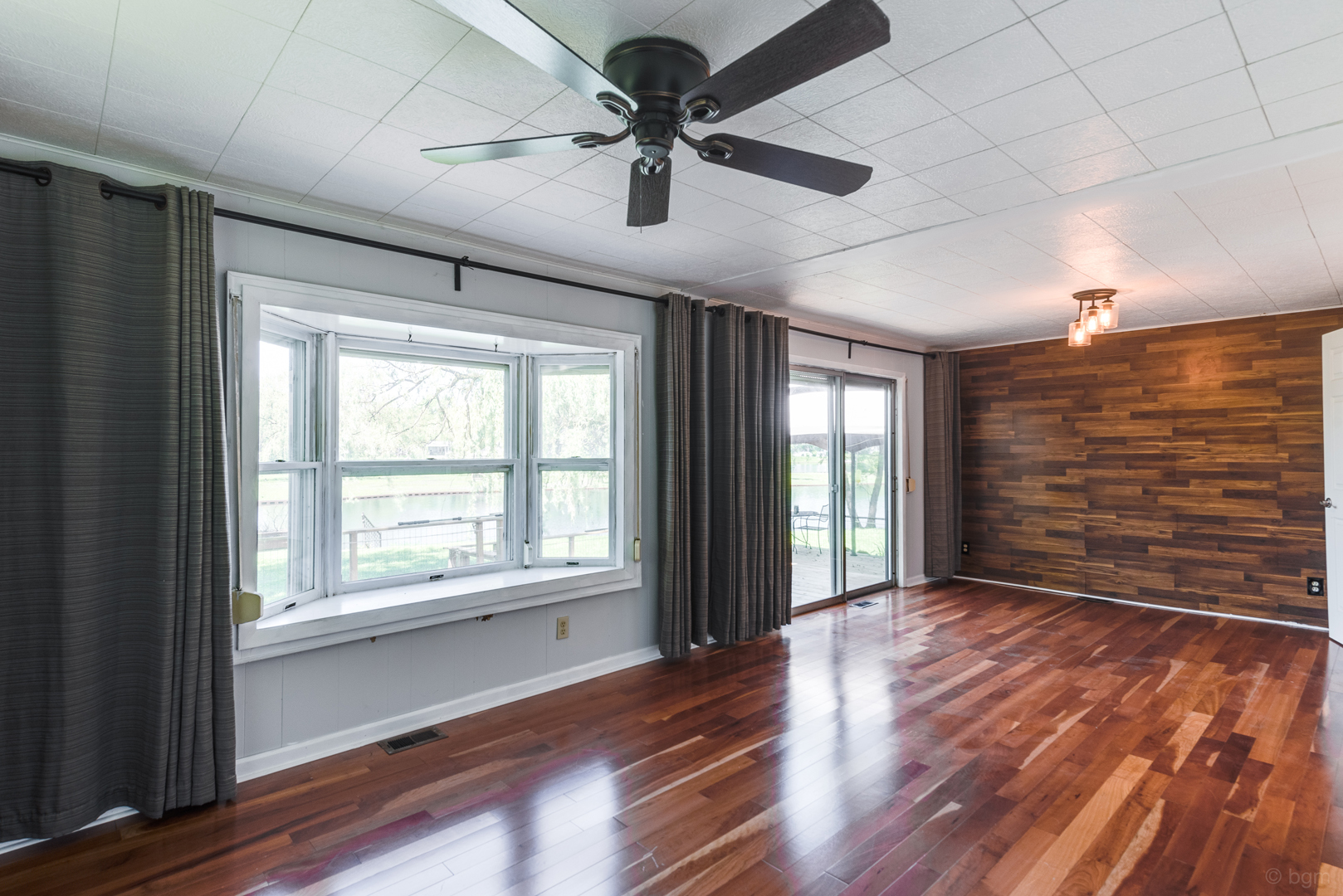 1110 Lakewood Road Elgin, IL 60123 - Photo 9 of 24 a view of an empty room with a window and wooden floor