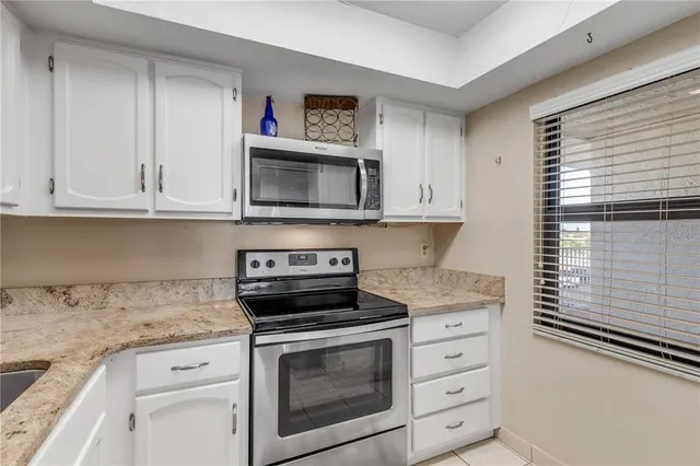 a bathroom with a granite countertop sink a toilet a mirror and shower