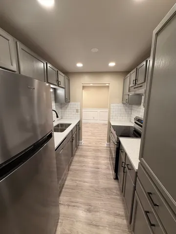 a kitchen with stainless steel appliances sink refrigerator and microwave