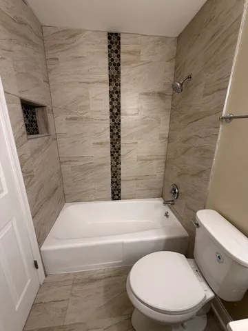 a bathroom with a toilet and a bath tub