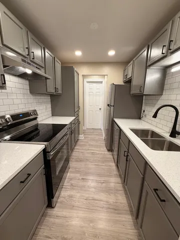 a kitchen with stainless steel appliances granite countertop a sink and a refrigerator