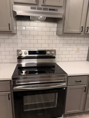 a stove top oven sitting inside of a kitchen