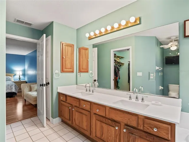 a bathroom with a granite countertop sink a toilet a mirror and shower