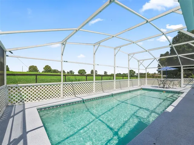 a big yard with lots of green space and trees in the back