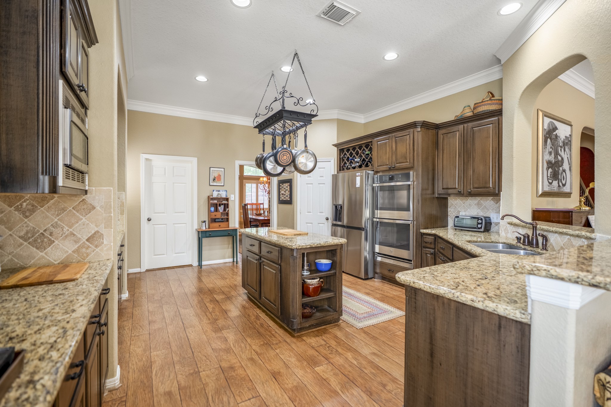 1438 Hatchmere Place Spring, TX 77379 - Photo 13 of 50 The kitchen offers a built-in wine rack, an abundance of storage as well as plenty of granite countertops for easy prep or serving space.