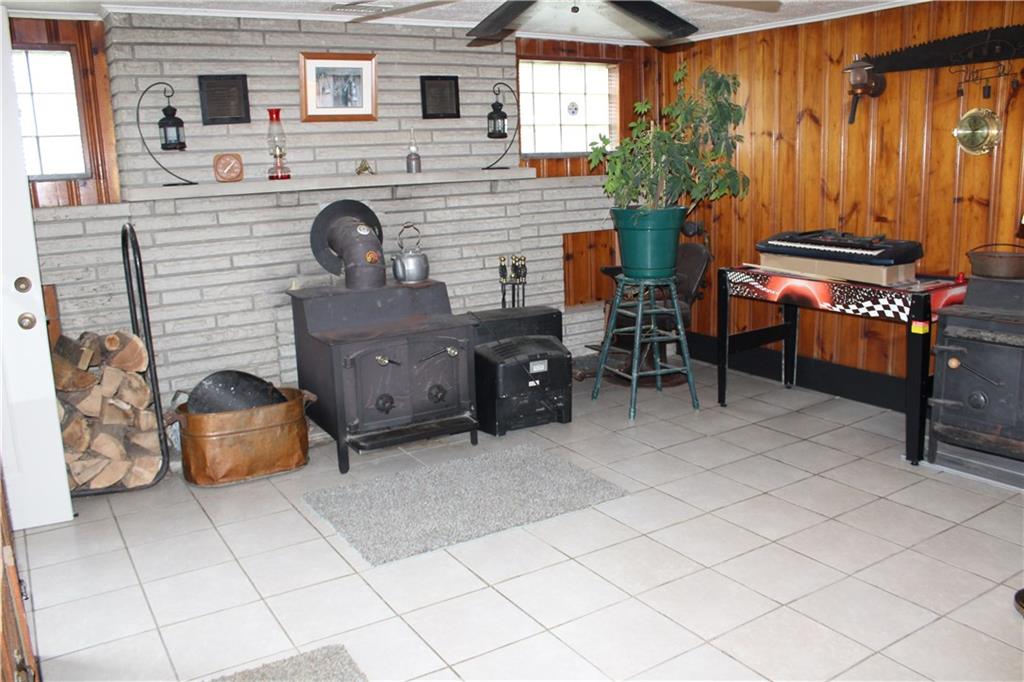 3241 Ridge Rd Extension Freedom, PA 15042 - Photo 10 of 16 Family room in basement with wood burning stove. Sauna and second wood stove are not included.