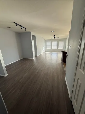 a view of a kitchen with refrigerator and wooden floor