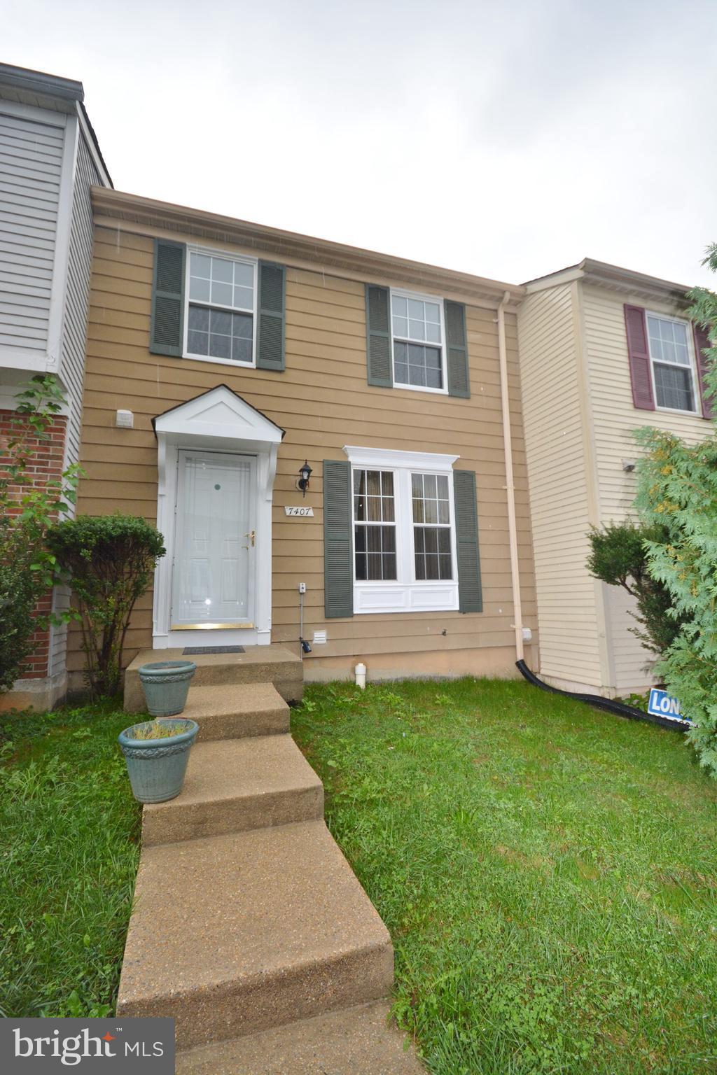 7407 Aspenpark Road Lorton, VA 22079 - Photo 1 of 12 a front view of a house with a garden