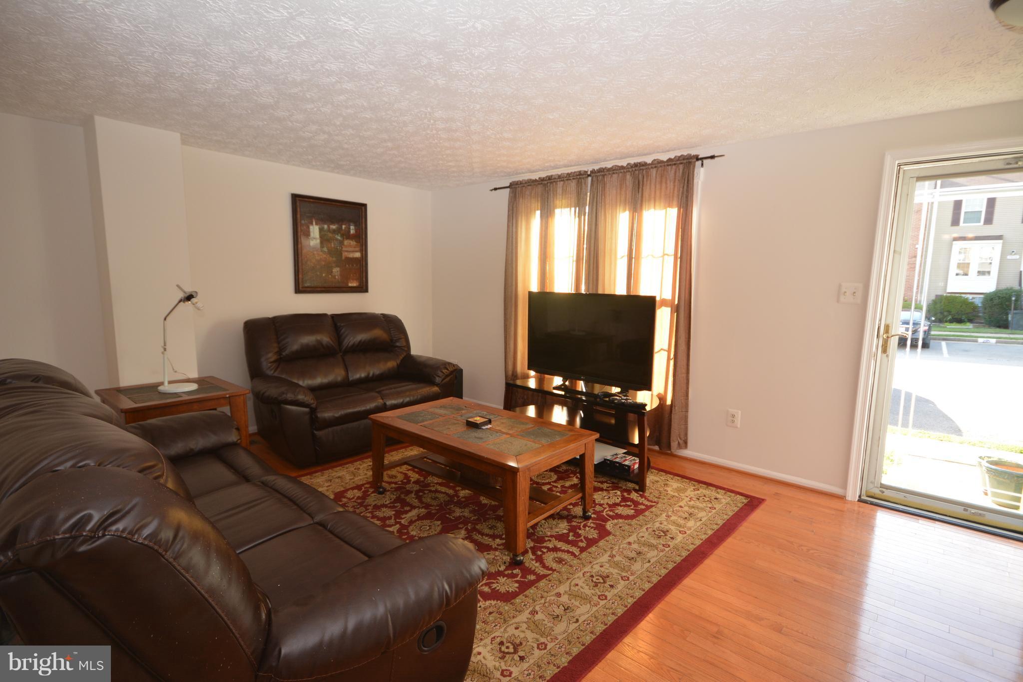 7407 Aspenpark Road Lorton, VA 22079 - Photo 2 of 12 a living room with furniture and a flat screen tv