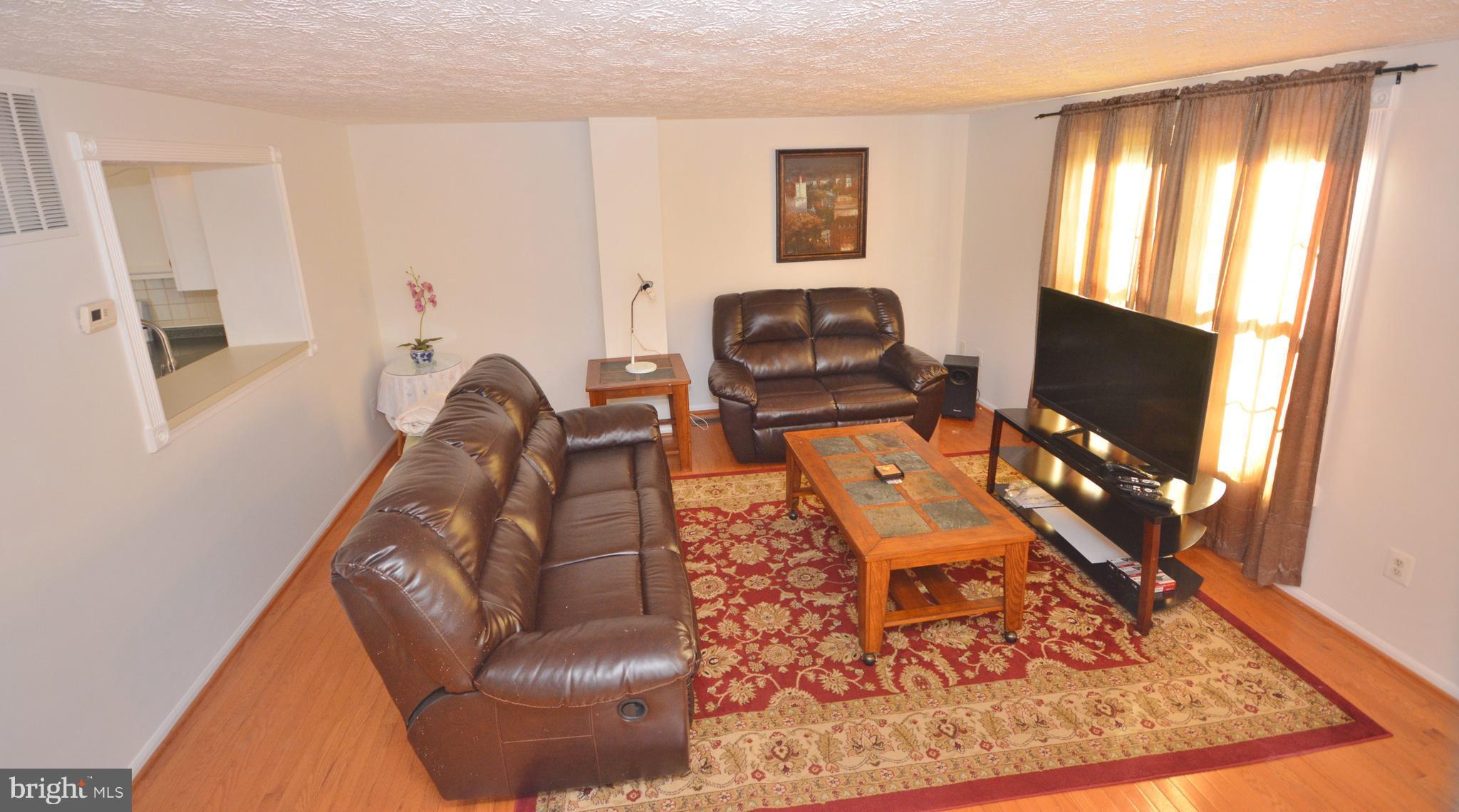 7407 Aspenpark Road Lorton, VA 22079 - Photo 4 of 12 a living room with furniture and a flat screen tv