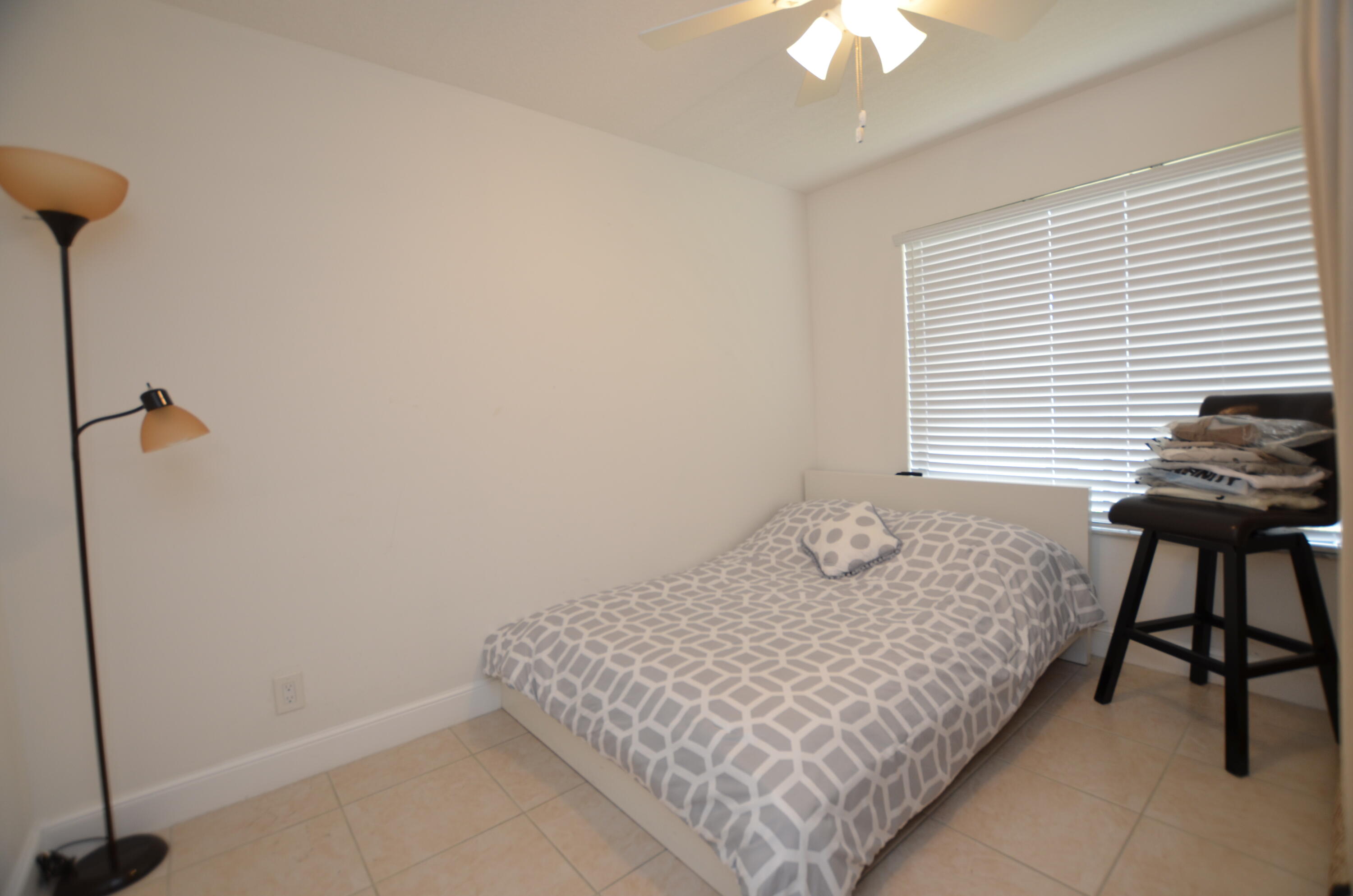 6649 Somerset Drive, Unit 102 Boca Raton, FL 33433 - Photo 14 of 19 a bedroom with a bed and a chandelier