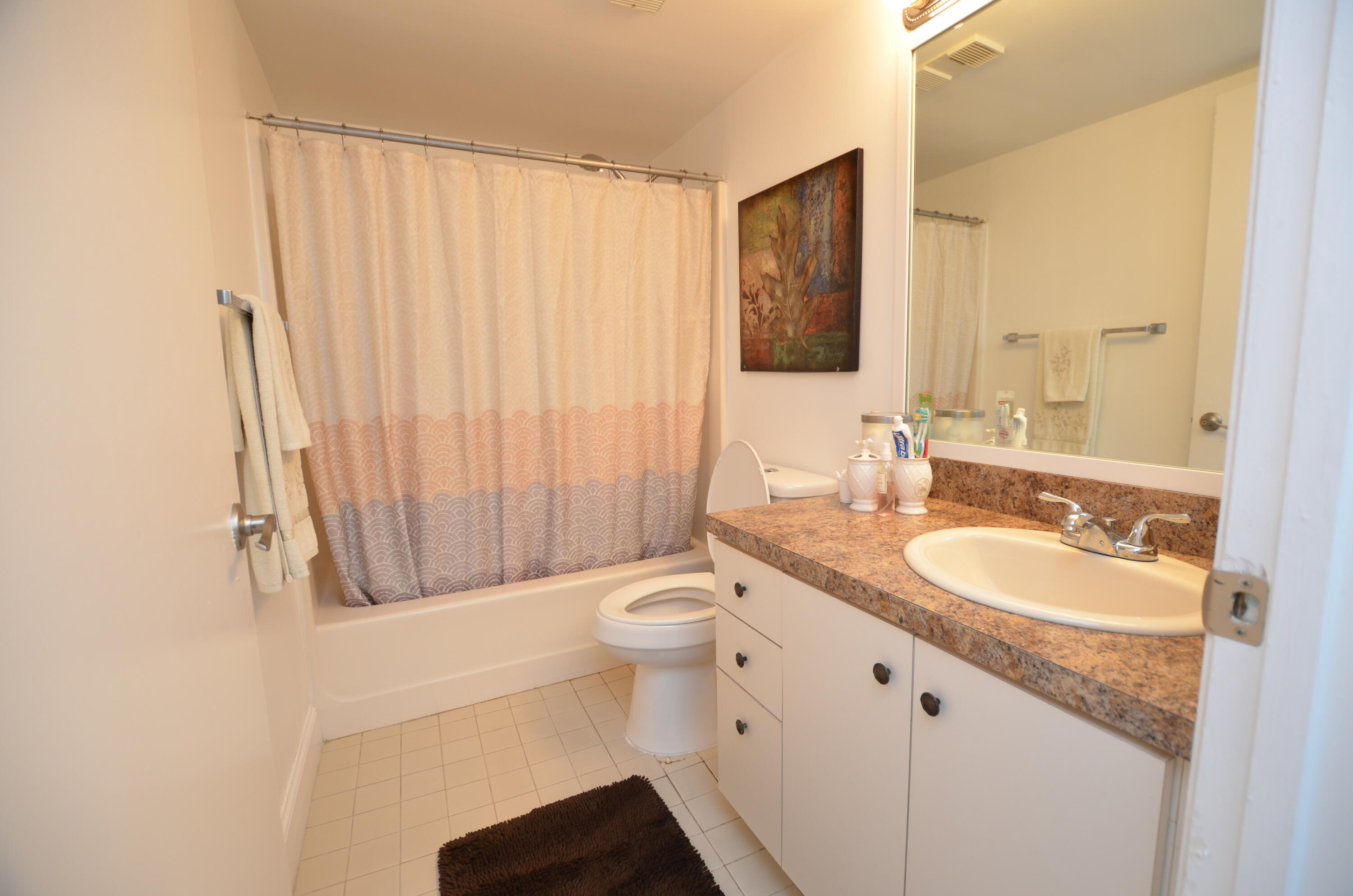 6649 Somerset Drive, Unit 102 Boca Raton, FL 33433 - Photo 16 of 19 a bathroom with a granite countertop sink toilet and mirror