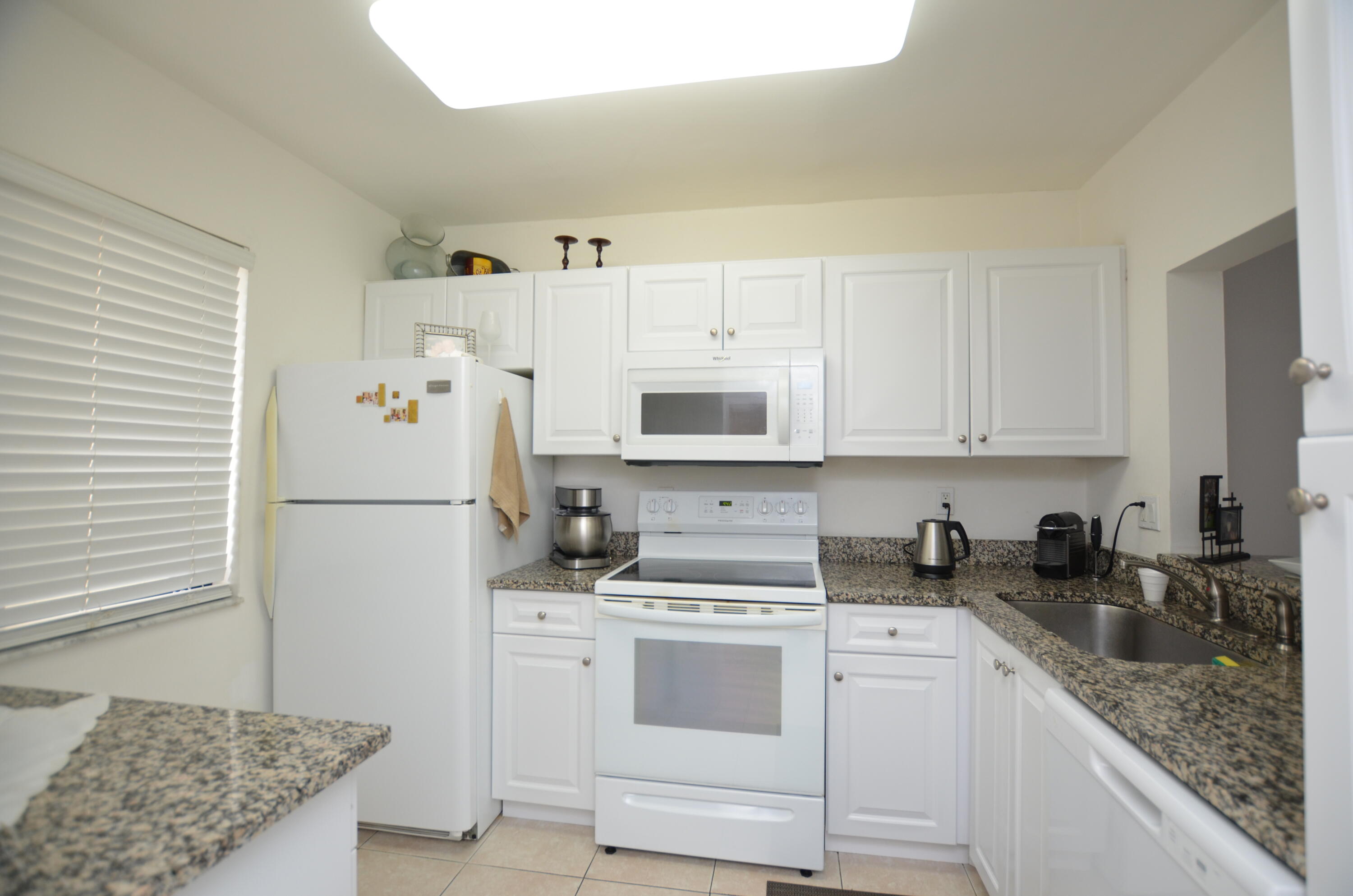 6649 Somerset Drive, Unit 102 Boca Raton, FL 33433 - Photo 2 of 19 a kitchen with white cabinets and white appliances