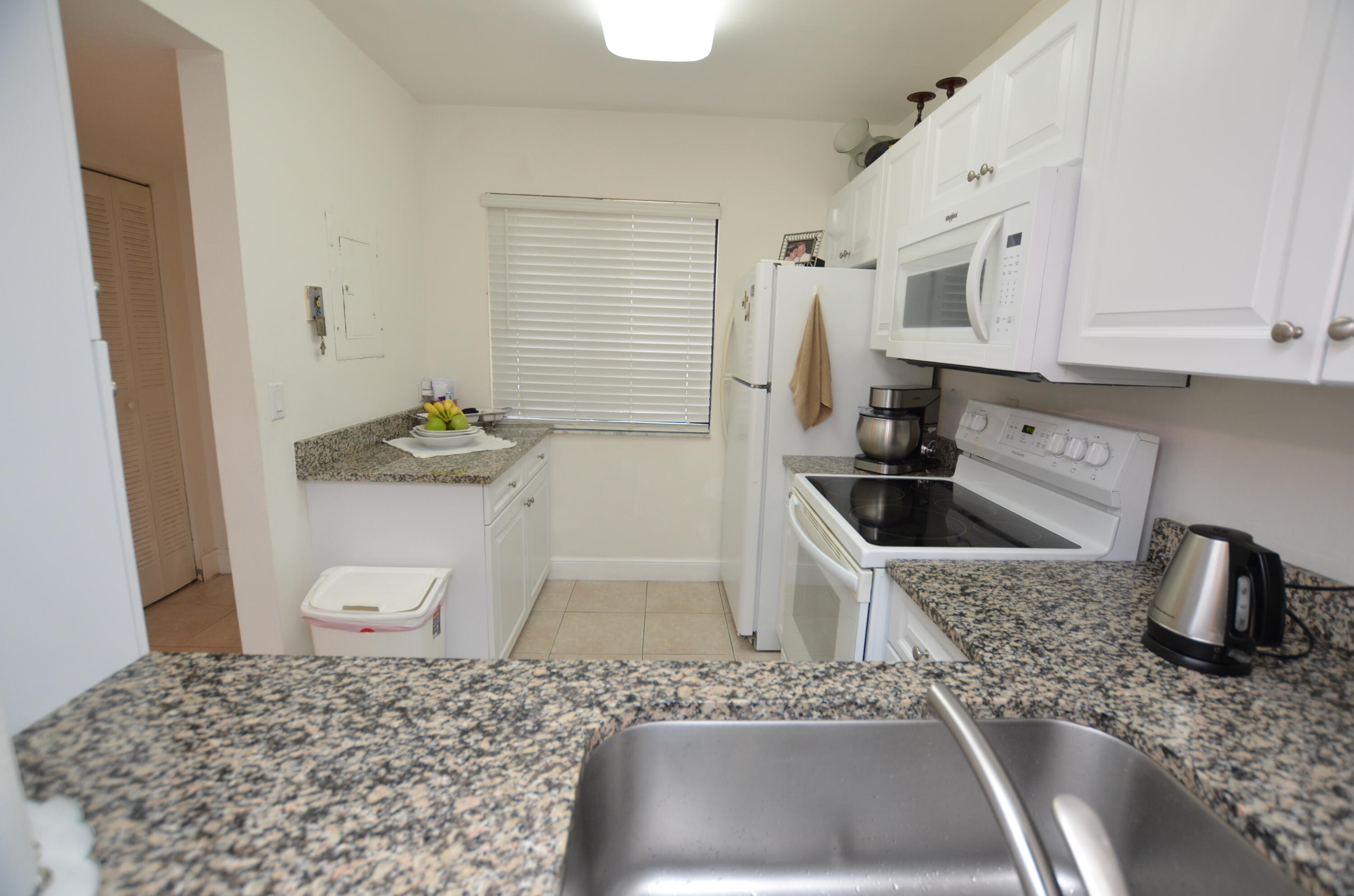 6649 Somerset Drive, Unit 102 Boca Raton, FL 33433 - Photo 4 of 19 a kitchen with a sink and a stove top oven