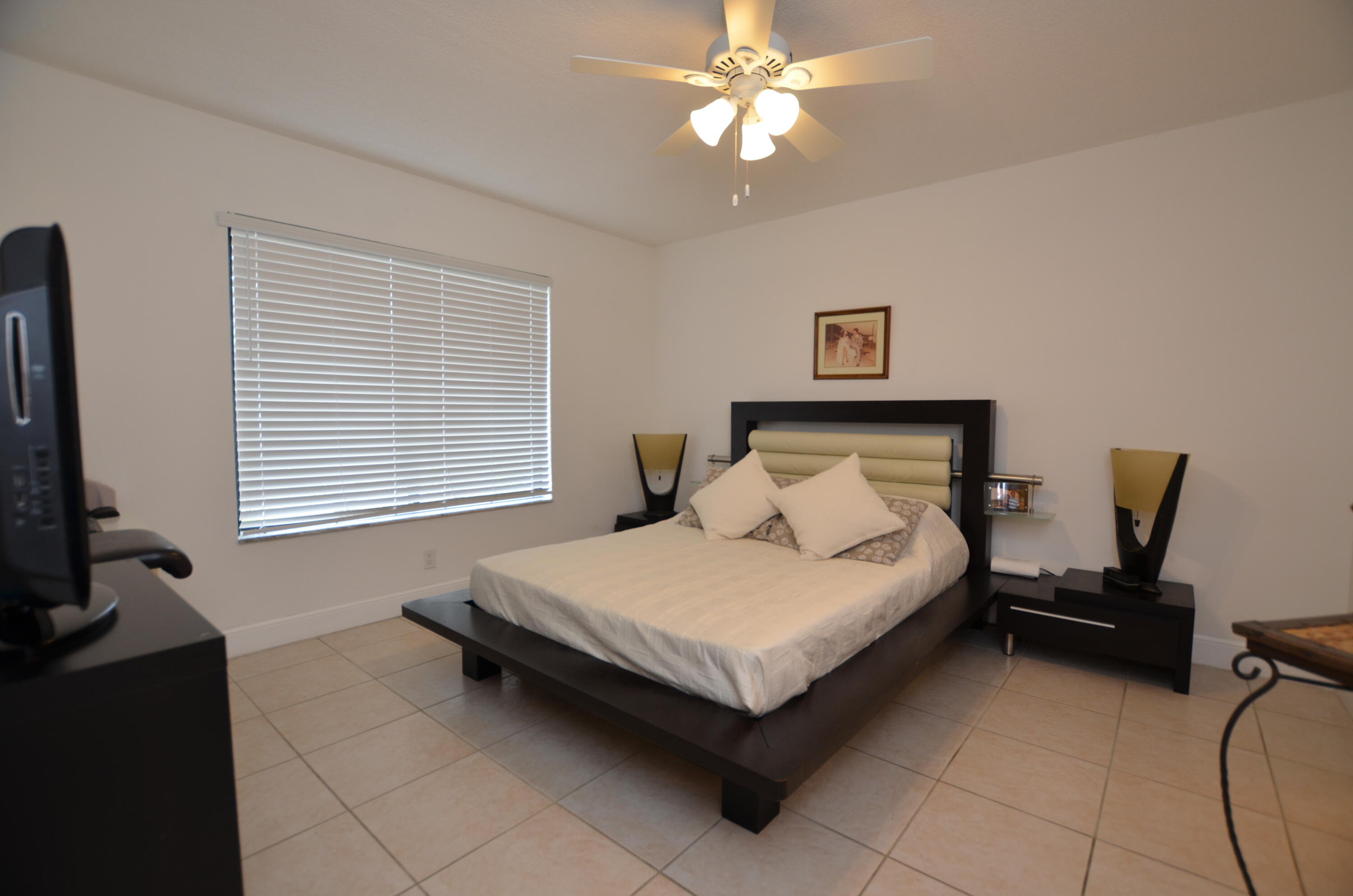 6649 Somerset Drive, Unit 102 Boca Raton, FL 33433 - Photo 8 of 19 a bedroom with a bed and a chandelier