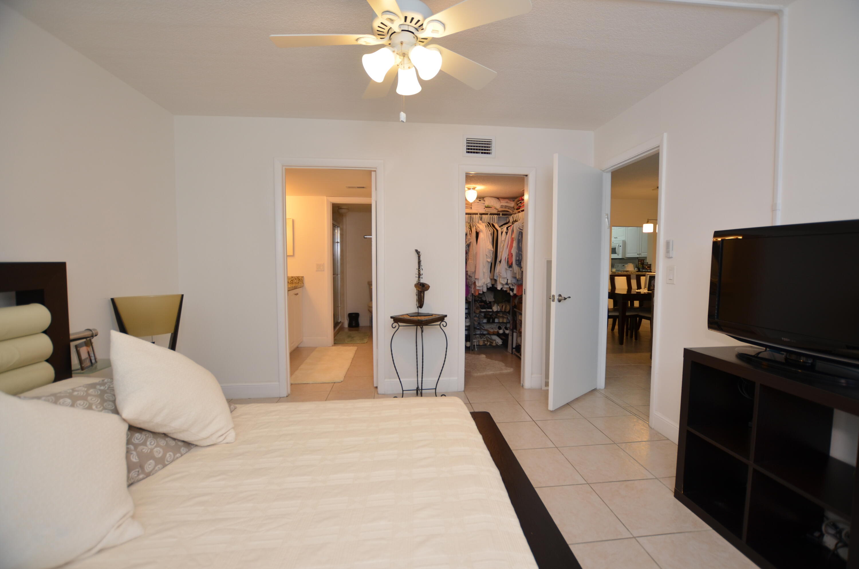 6649 Somerset Drive, Unit 102 Boca Raton, FL 33433 - Photo 9 of 19 a bedroom with a bed and a flat screen tv