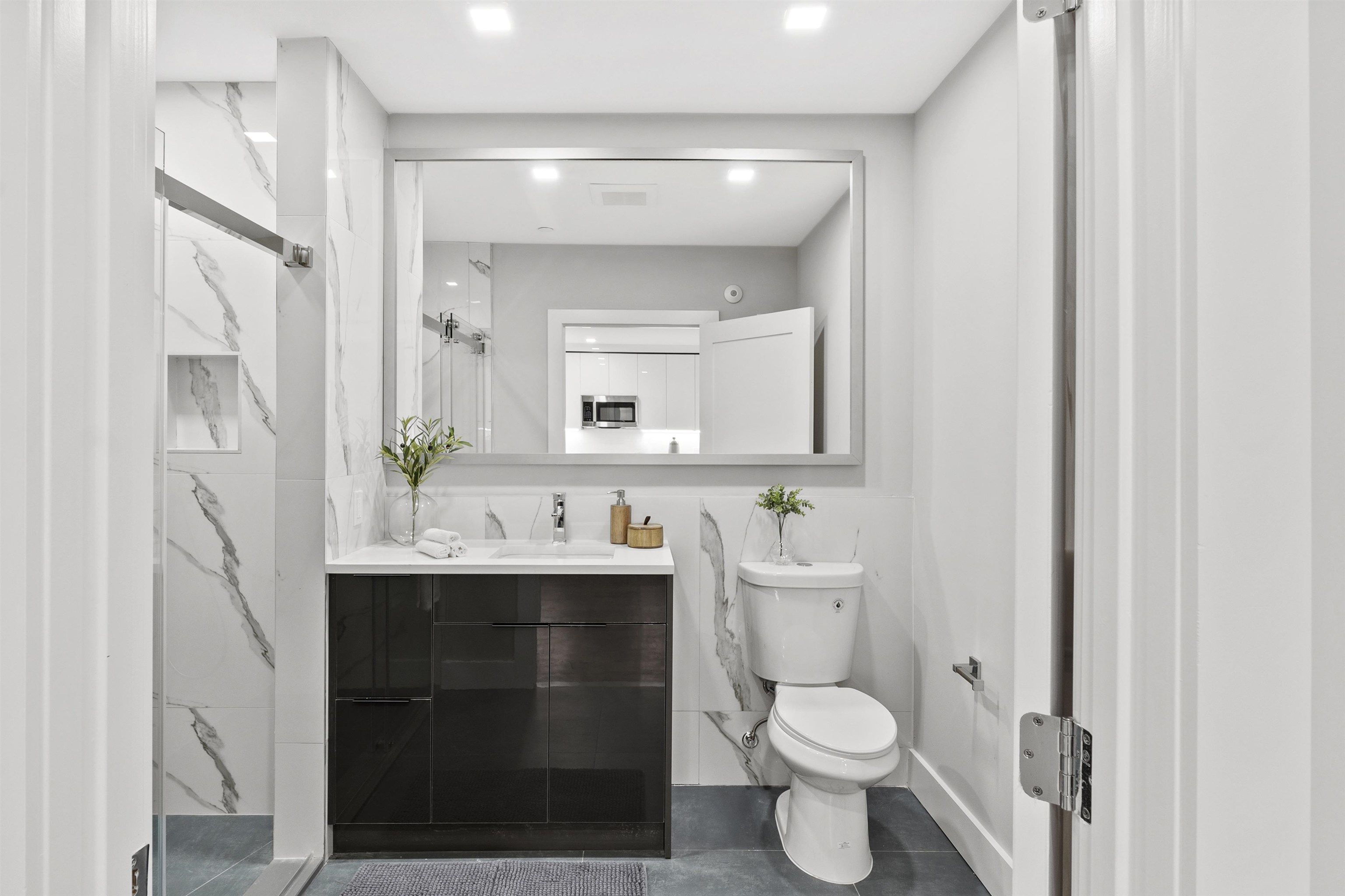 60-64 68th Street, Unit 208 Guttenberg, NJ 07093 - Photo 24 of 29 a bathroom with a toilet sink and mirror