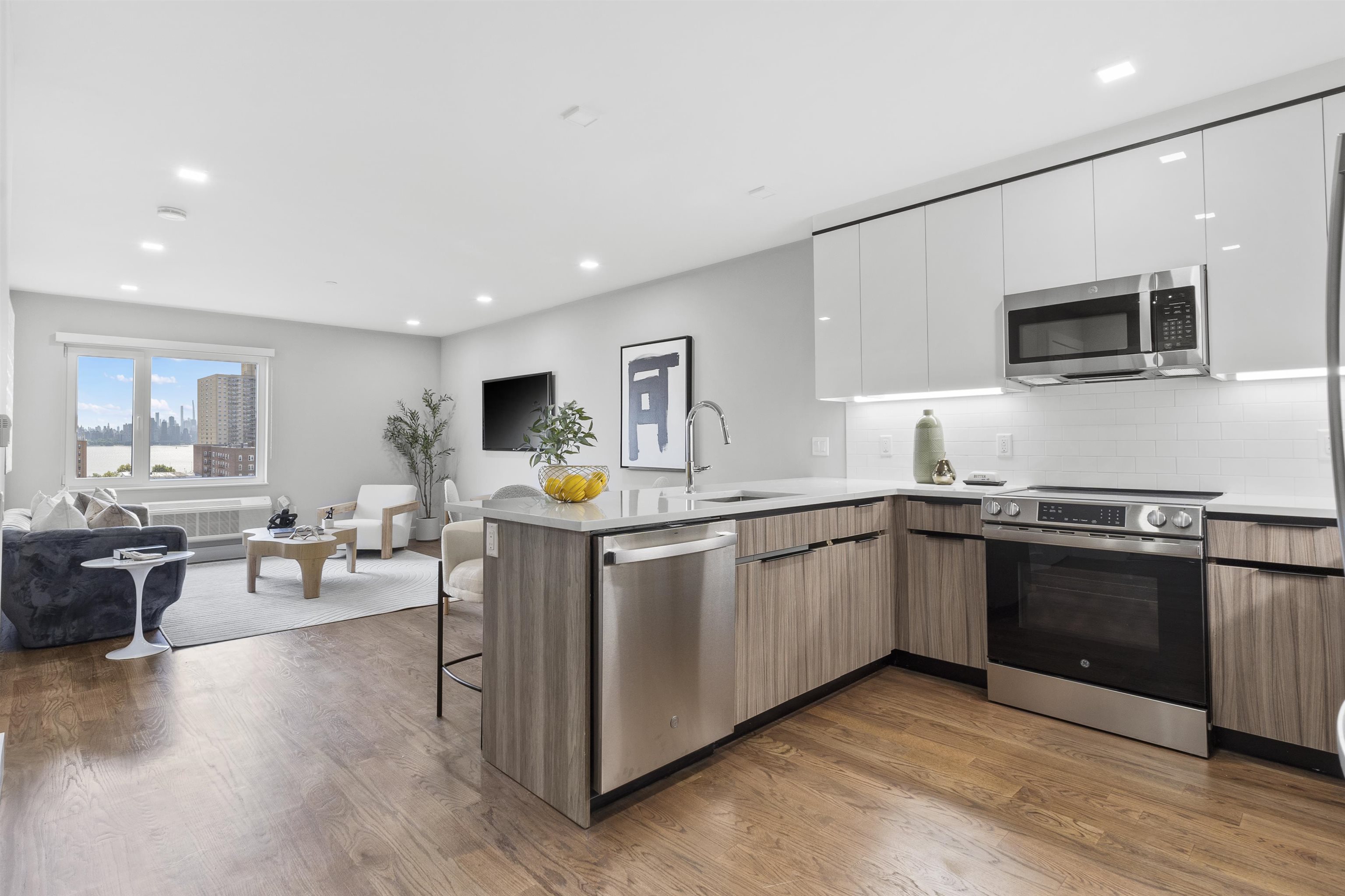 60-64 68th Street, Unit 208 Guttenberg, NJ 07093 - Photo 4 of 29 a kitchen with stainless steel appliances granite countertop a stove top oven a sink dishwasher and a microwave oven with wooden floor
