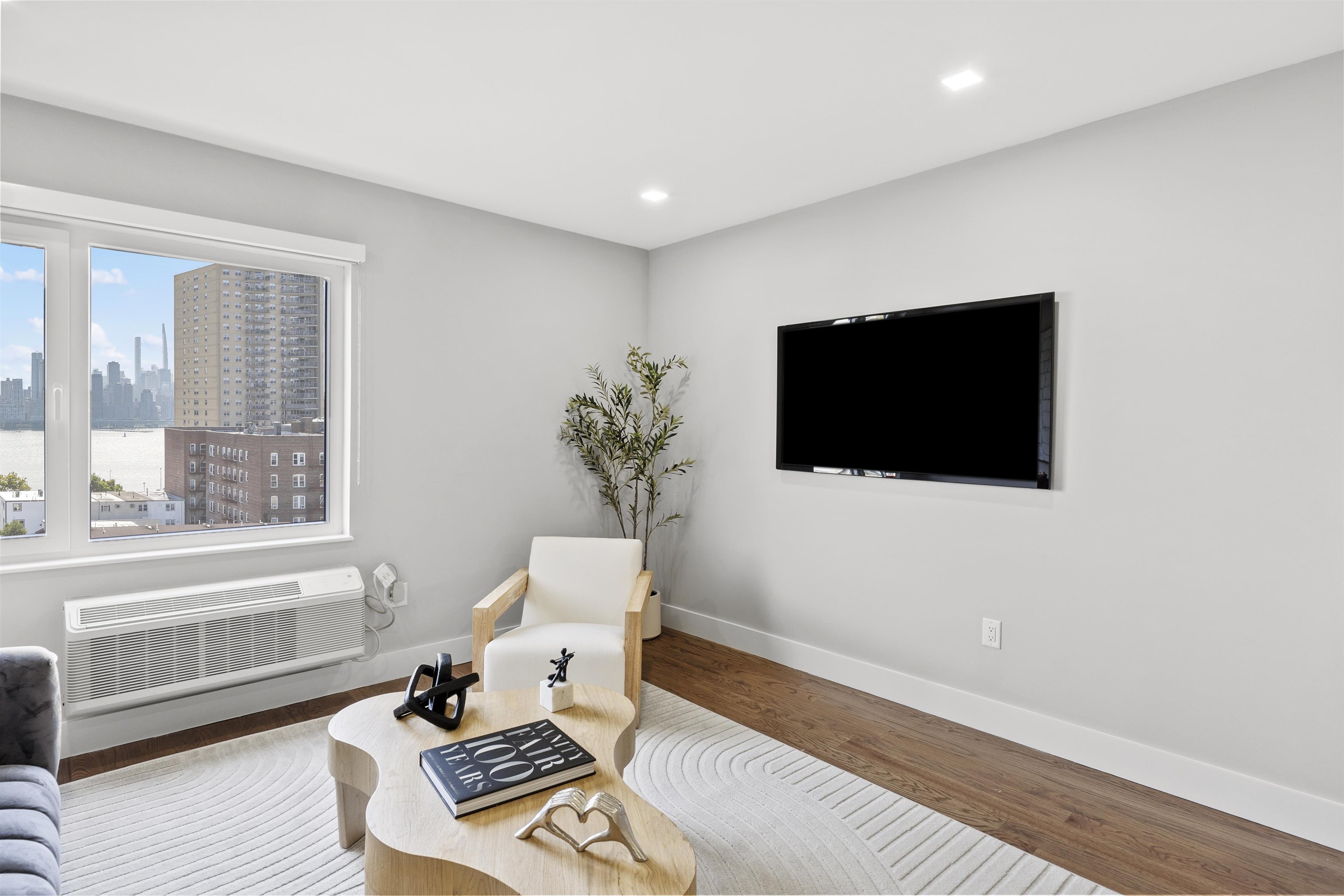 60-64 68th Street, Unit 208 Guttenberg, NJ 07093 - Photo 10 of 29 a living room with furniture and a flat screen tv