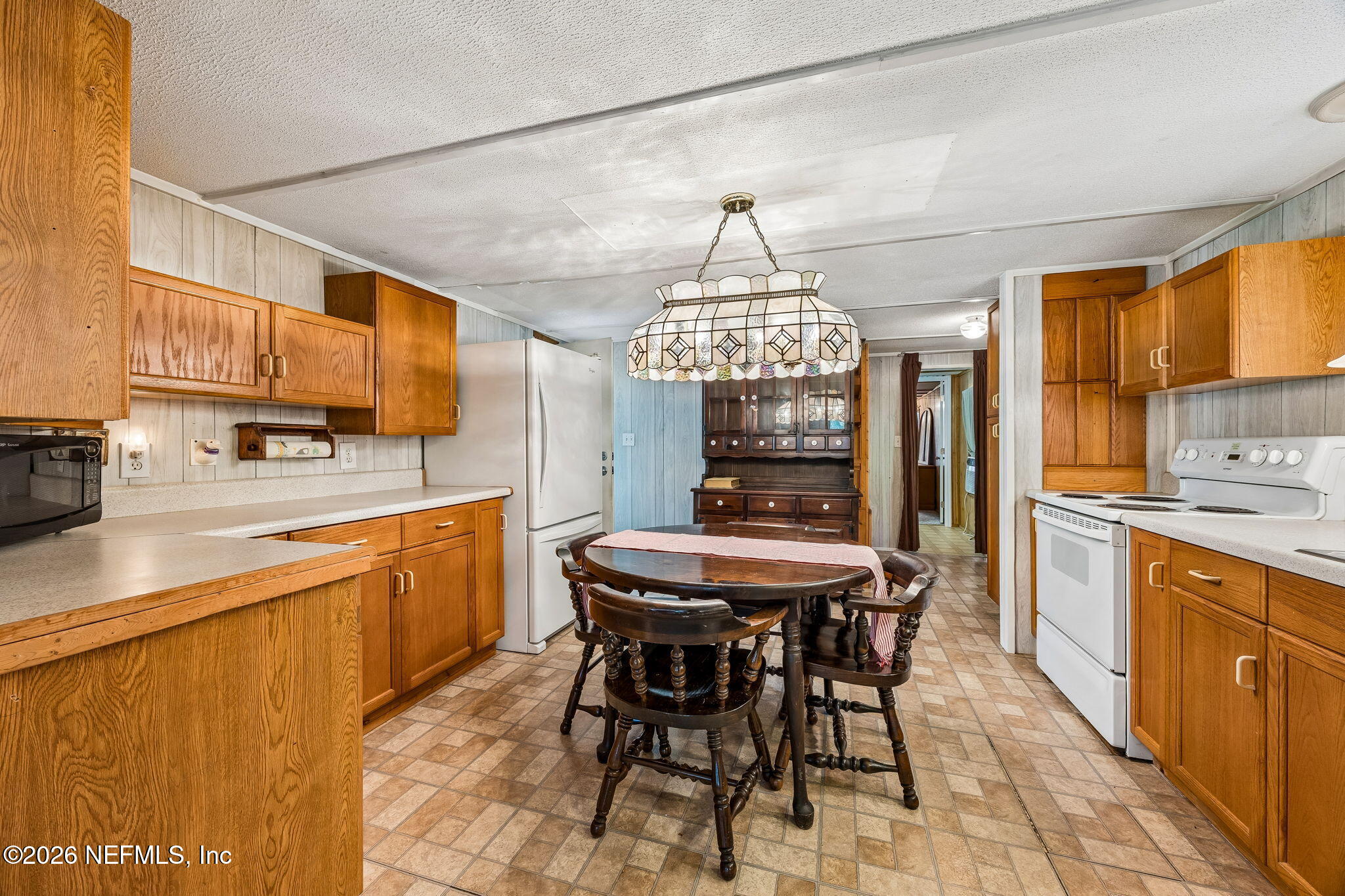 15690 Sears Road Jacksonville, FL 32218 - Photo 10 of 27 a kitchen with stainless steel appliances a table and chairs in it