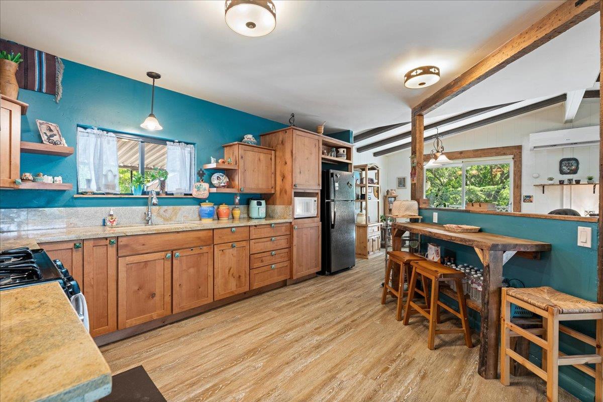 4420 Pleasant Valley Road, Unit 131 Diamond Springs, CA 95619 - Photo 4 of 30 a kitchen with stainless steel appliances granite countertop a table chairs and a refrigerator
