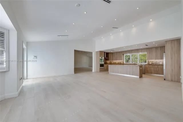 a view of an empty room with a cabinet and a window