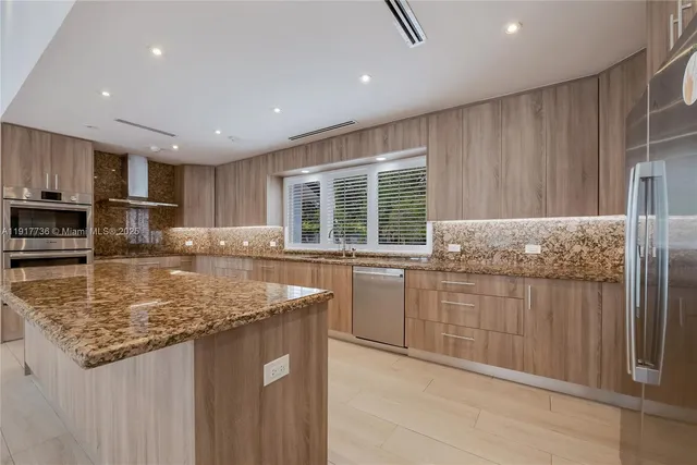 a kitchen with kitchen island granite countertop a sink counter top space and appliances