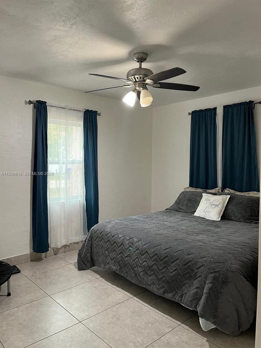 2116 Monroe Terrace Hollywood, FL 33020 - Photo 28 of 40 a bedroom with a large bed and a chandelier