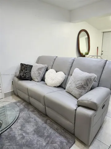 a living room with furniture a lamp and a potted plant