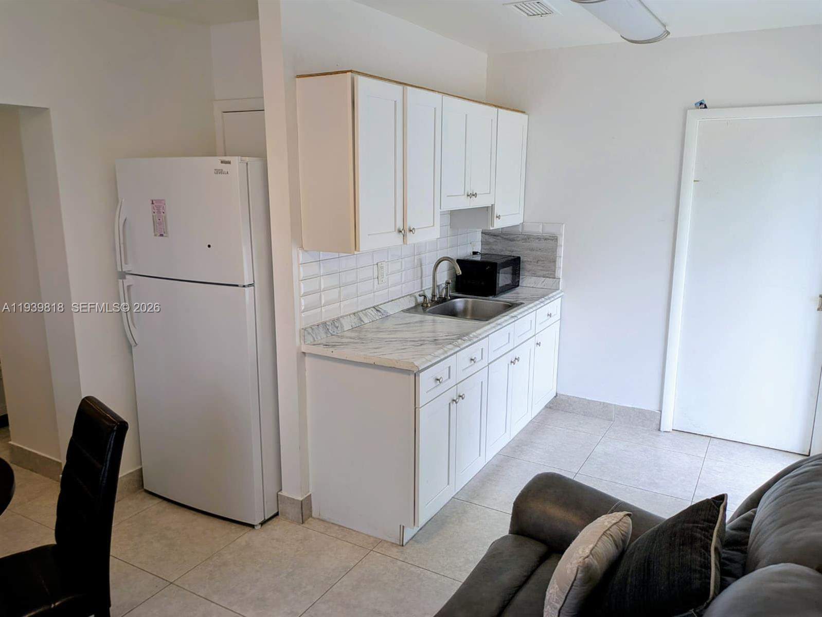 2116 Monroe Terrace Hollywood, FL 33020 - Photo 39 of 40 a kitchen with stainless steel appliances white cabinets and wooden floor
