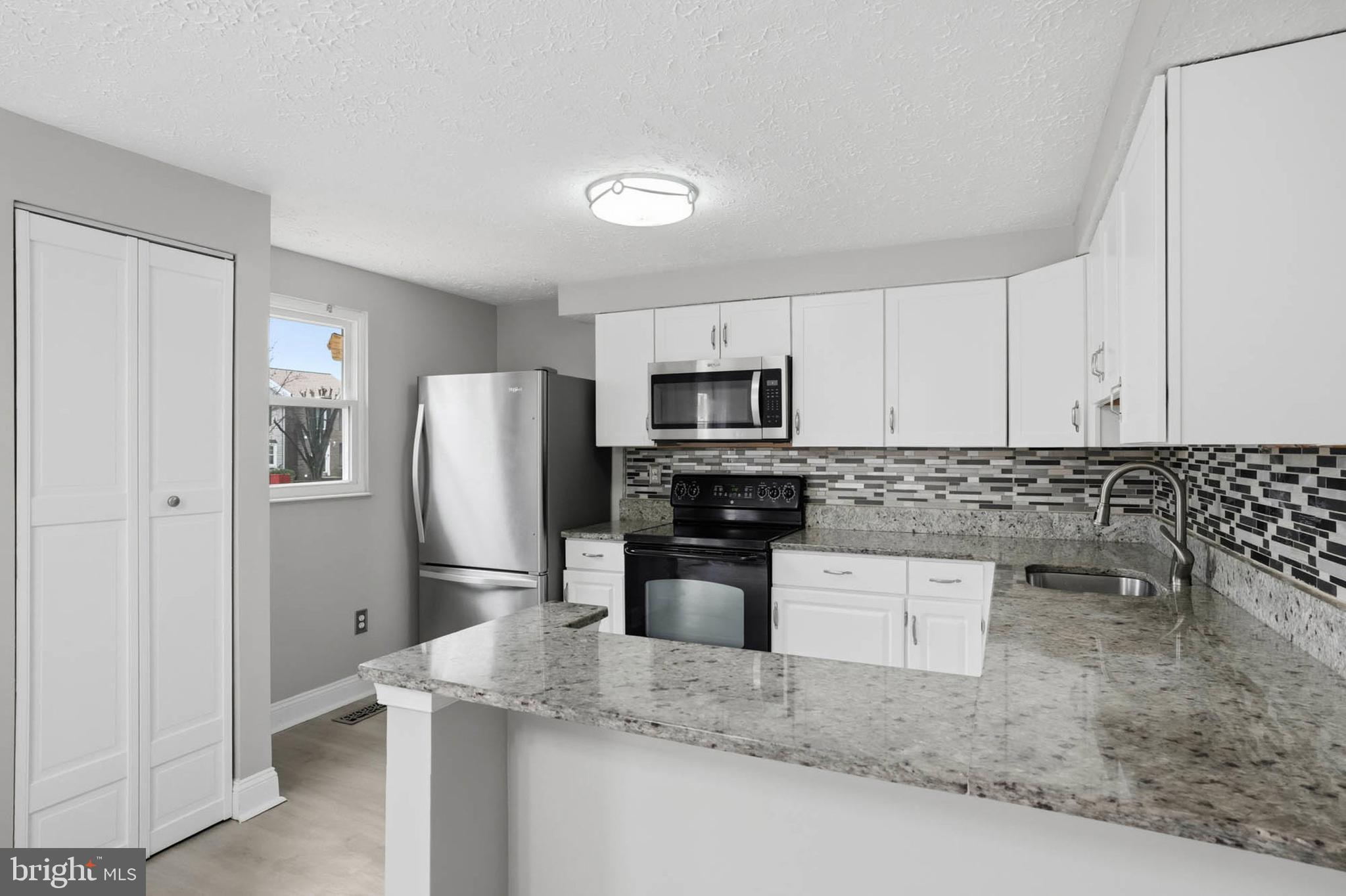 9931 Tuscarora Road Randallstown, MD 21133 - Photo 11 of 30 a kitchen with stainless steel appliances granite countertop a refrigerator sink and stove