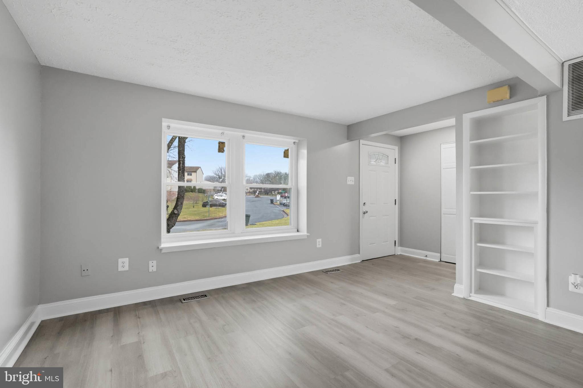 9931 Tuscarora Road Randallstown, MD 21133 - Photo 5 of 30 a view of an empty room with a window and wooden floor