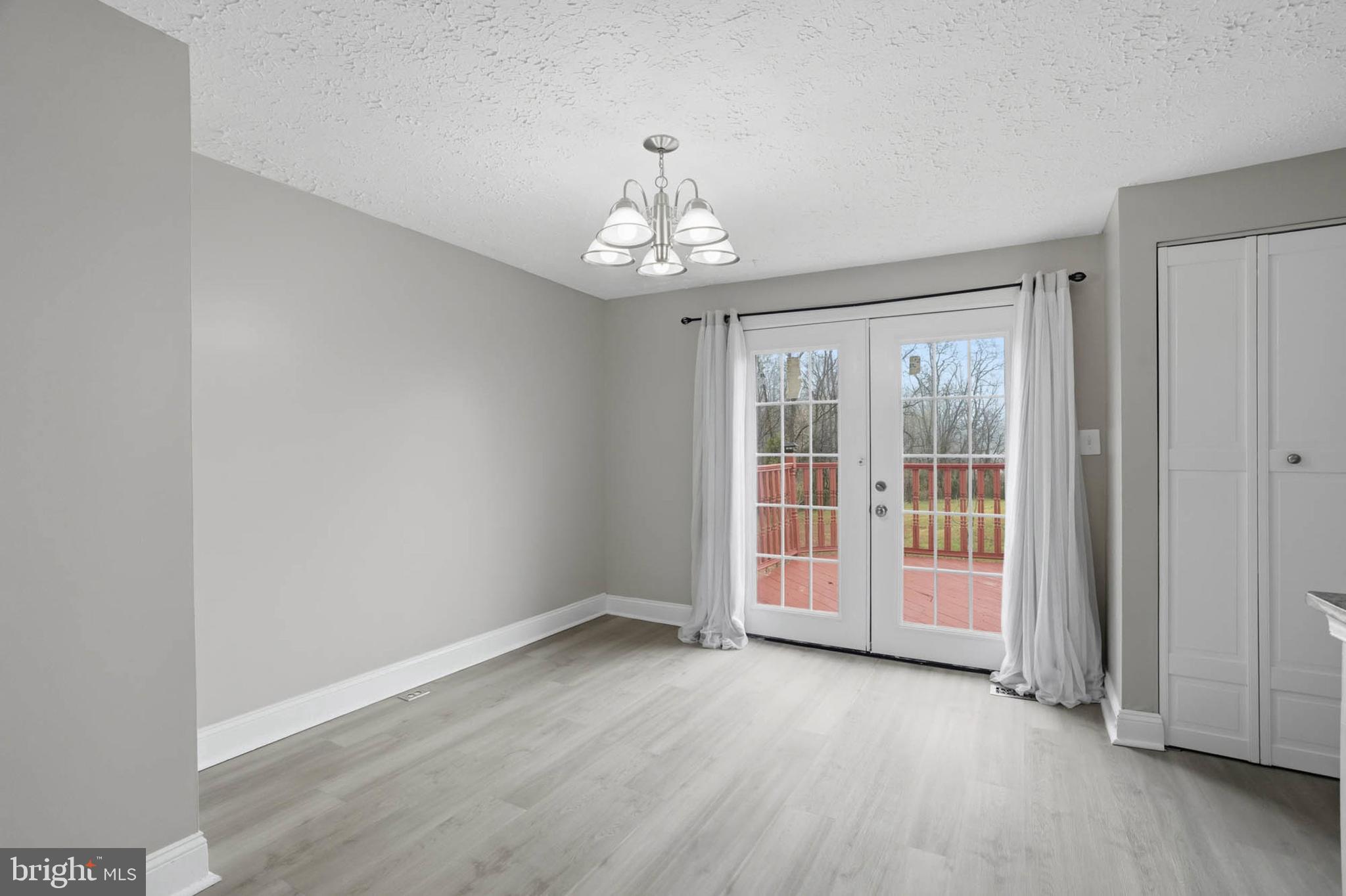 9931 Tuscarora Road Randallstown, MD 21133 - Photo 9 of 30 an empty room with wooden floor and windows