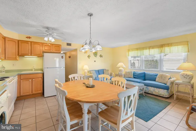 a view of a dining room and livingroom with furniture wooden floor a chandelier