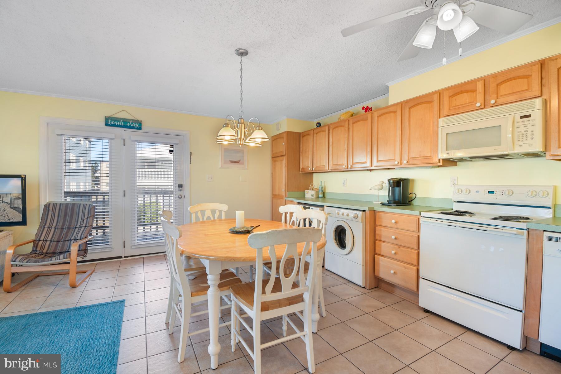 13 75th Street, Unit 1W Ocean City, MD 21842 - Photo 5 of 26 a kitchen with stainless steel appliances granite countertop a stove top oven a dining table and chairs with wooden floor