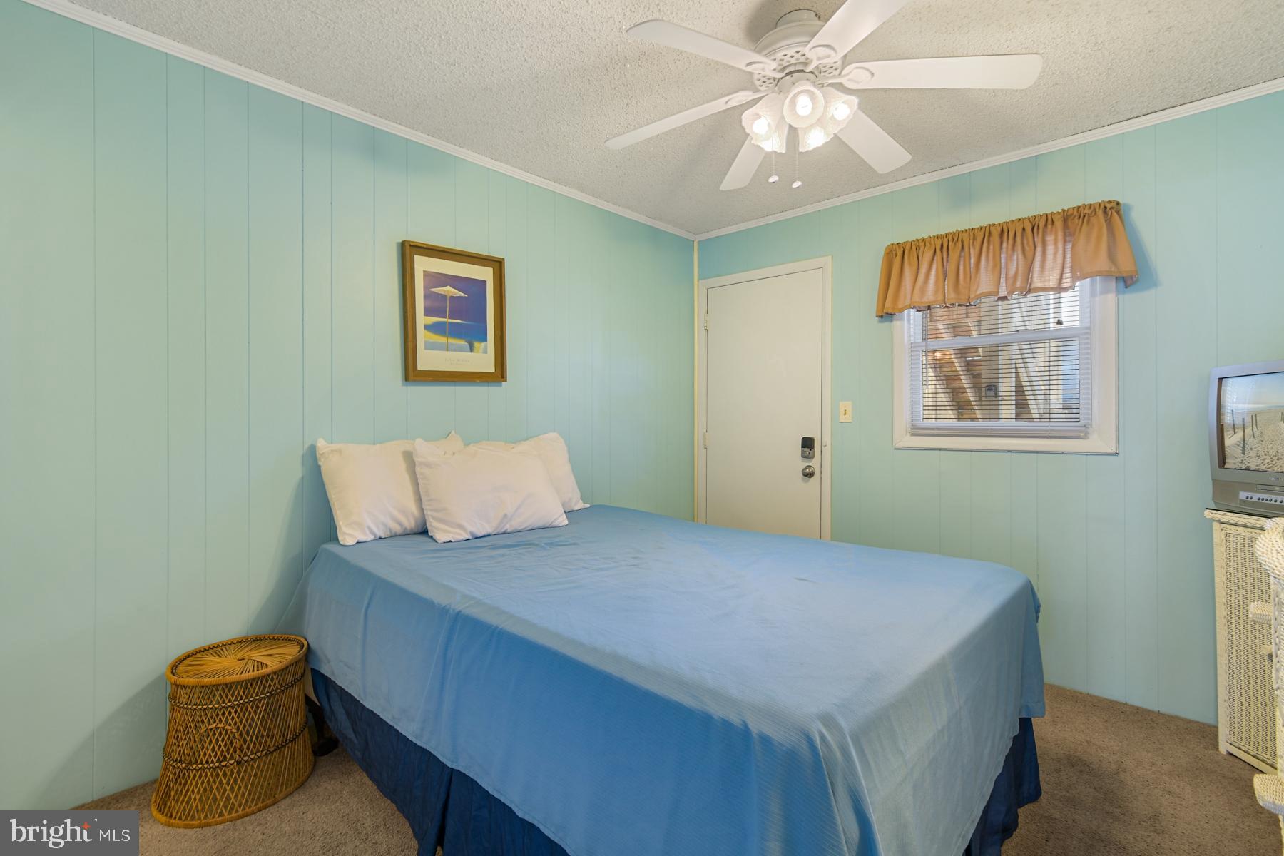 13 75th Street, Unit 1W Ocean City, MD 21842 - Photo 8 of 26 a bedroom with a bed and a chandelier