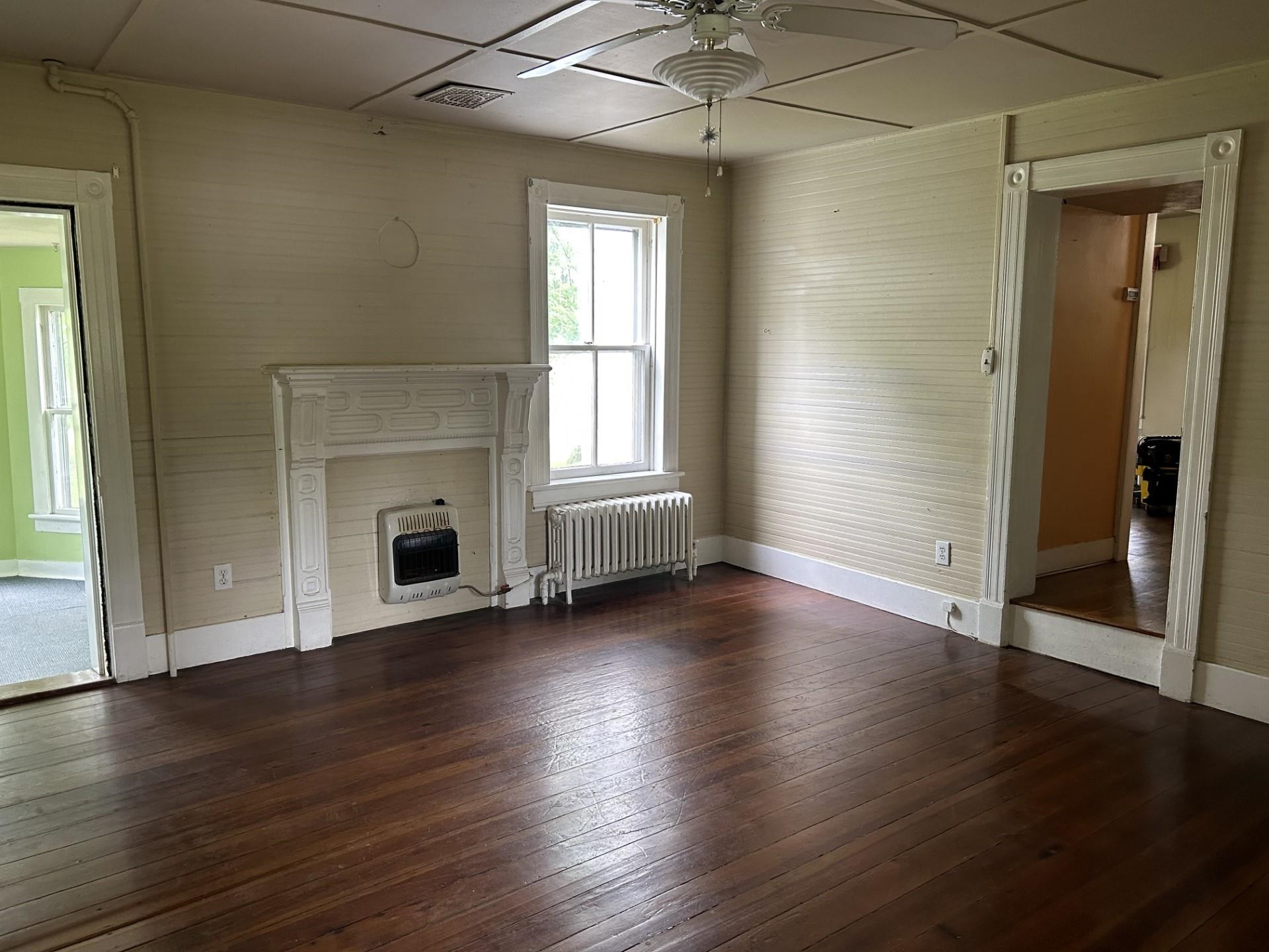 29 Tye River Turnpike Raphine, VA 24472 - Photo 5 of 17 an empty room with wooden floor fireplace and windows