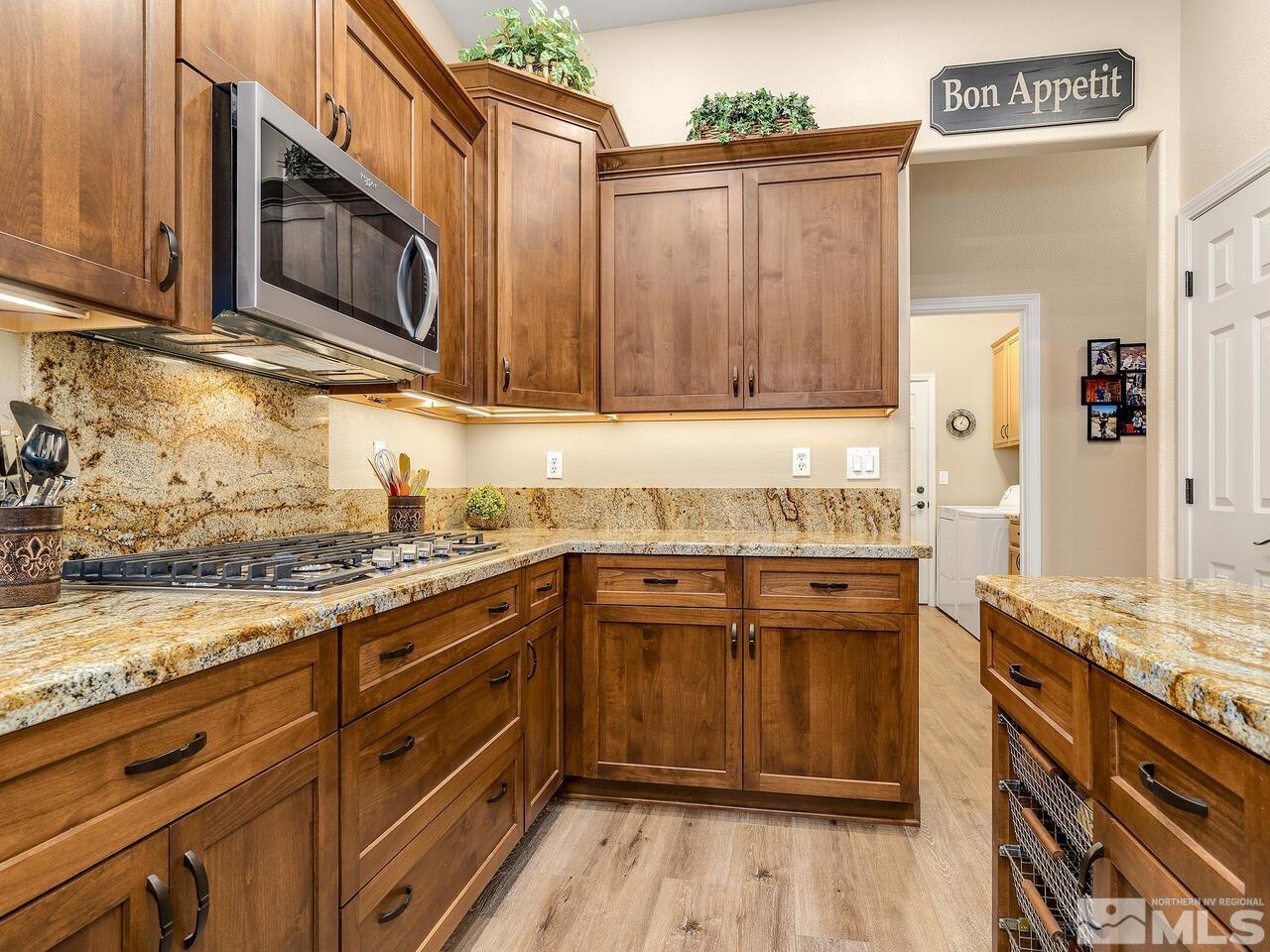 9684 Rolling Rock Way Reno, NV 89521 - Photo 10 of 34 a kitchen with stainless steel appliances granite countertop a stove a sink and a microwave