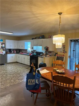 a kitchen with a dining table chairs and a refrigerator