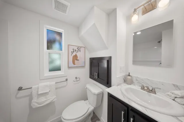 a bathroom with a toilet sink and mirror
