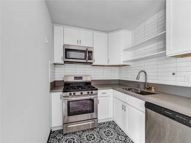 a kitchen with cabinets stainless steel appliances and a sink