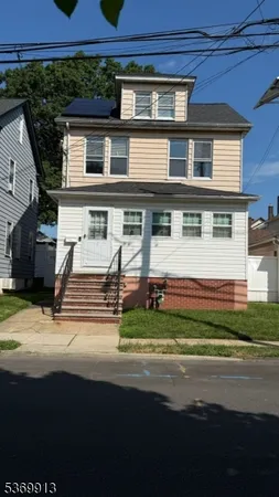 a front view of a house with a garden and trees